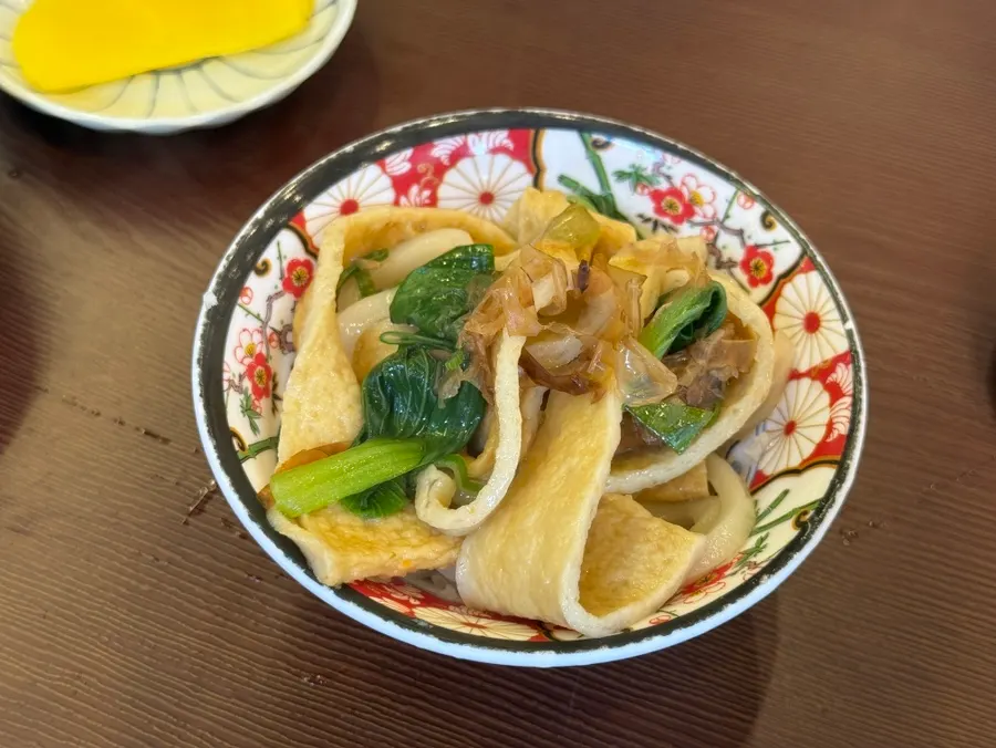 スパイシークリームトンカツのソースにつけたトンカツの一切れ