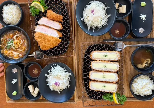 Table set with Kkot Gatsu's pork cutlet spread