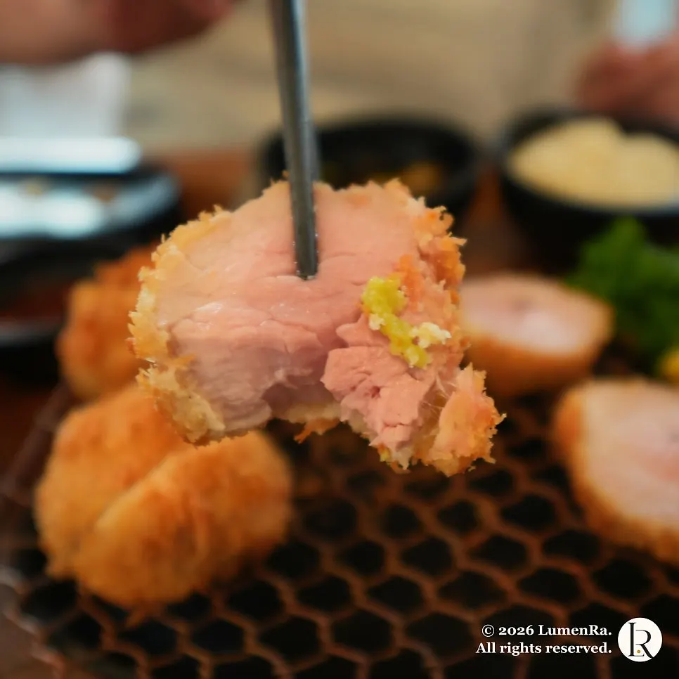 A bite of kkot katsu dipped in lemon salt