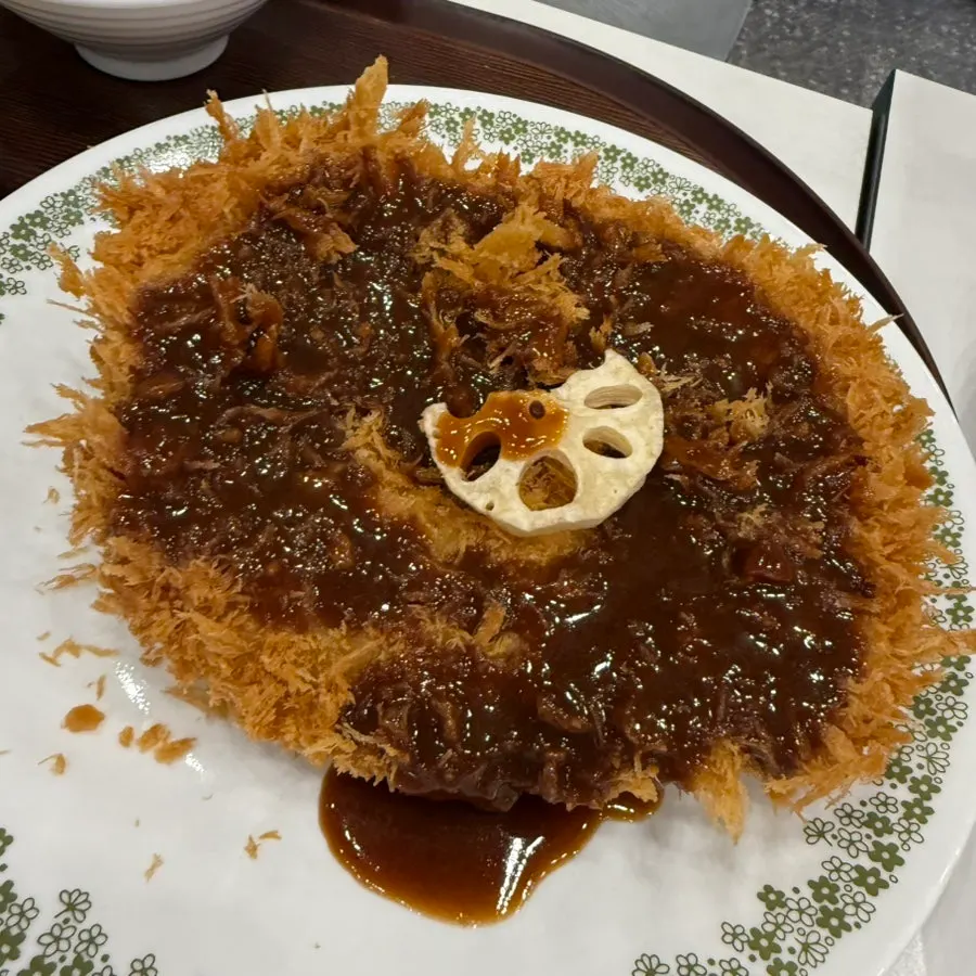 Crispy basic pork cutlet topped with a lotus root chip