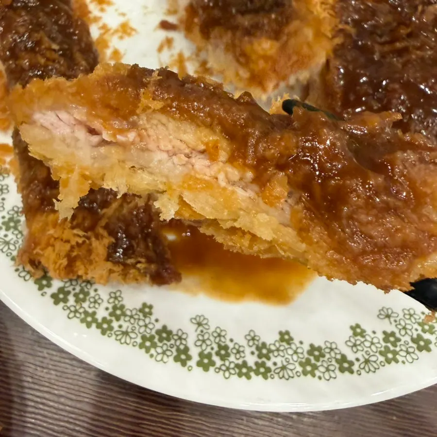 Cross-section of a thick pork cutlet with sauce poured over it