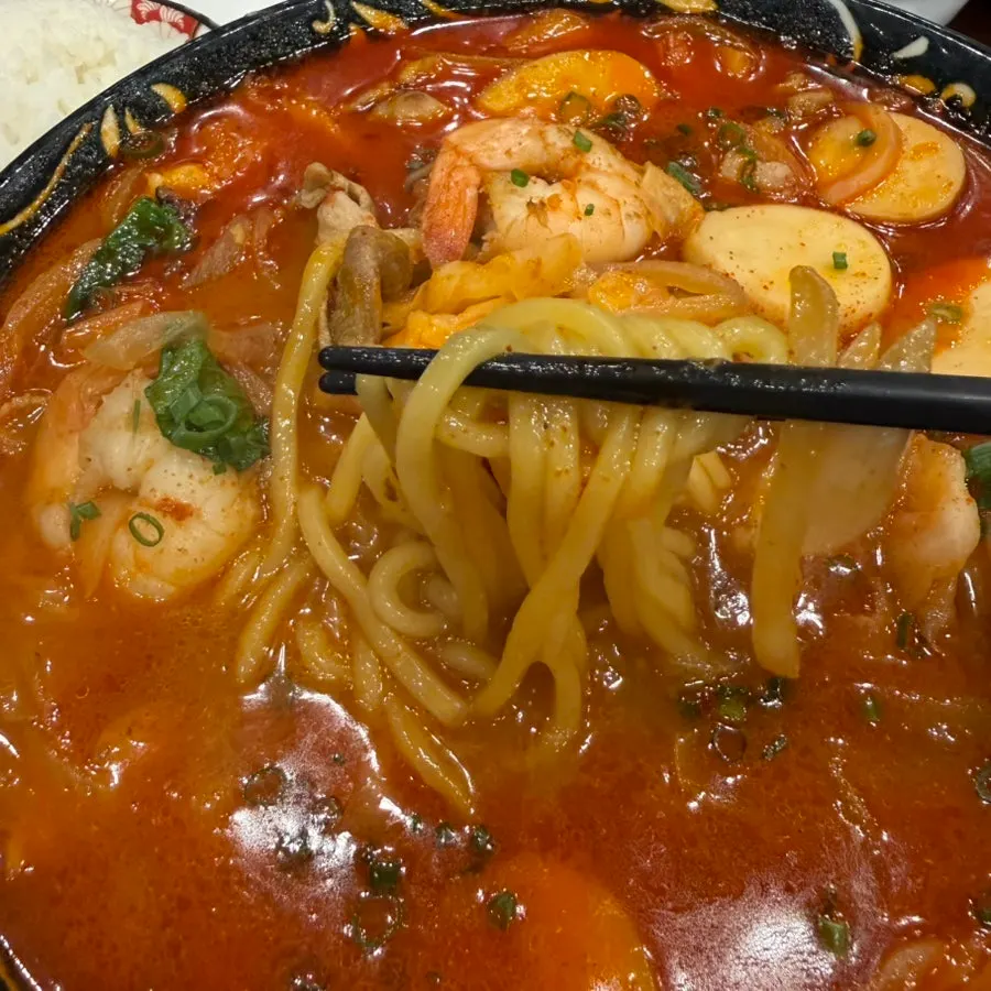 Chewy jjamppong noodles lifted with chopsticks