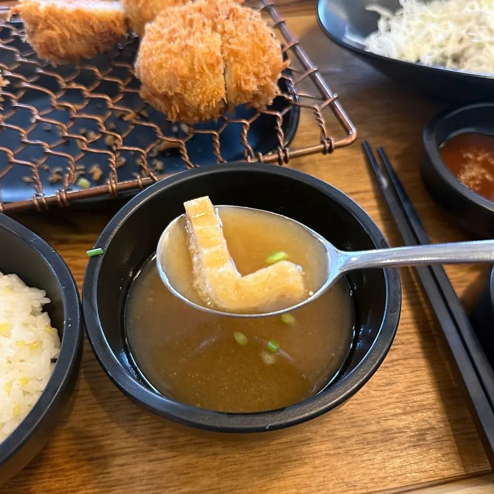 A piece of Kkot Gatsu pork cutlet dipped in salt