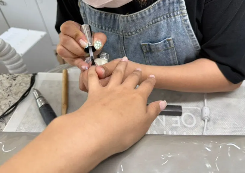 Thin base coats being applied during the gel nail process