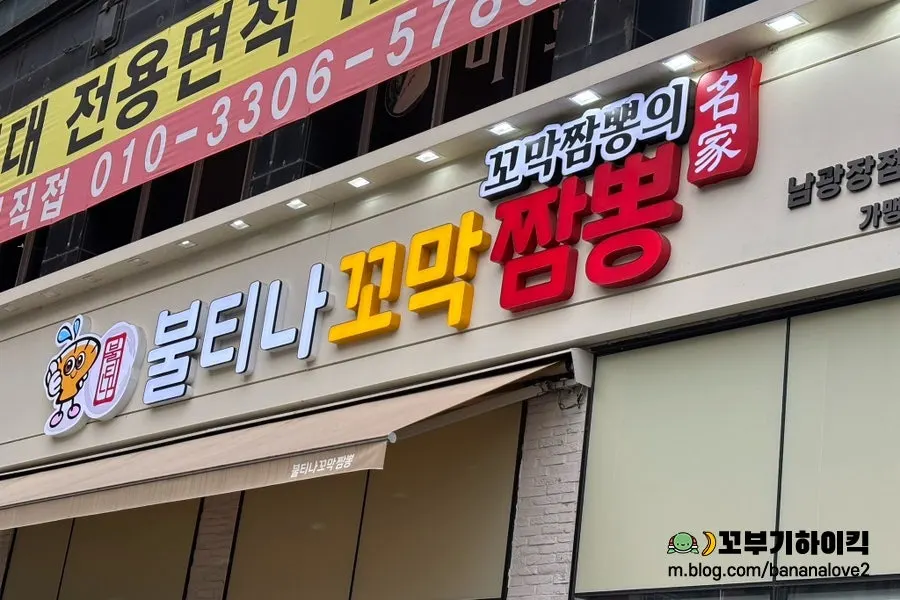 Large signboard photo of cockle jjamppong out front