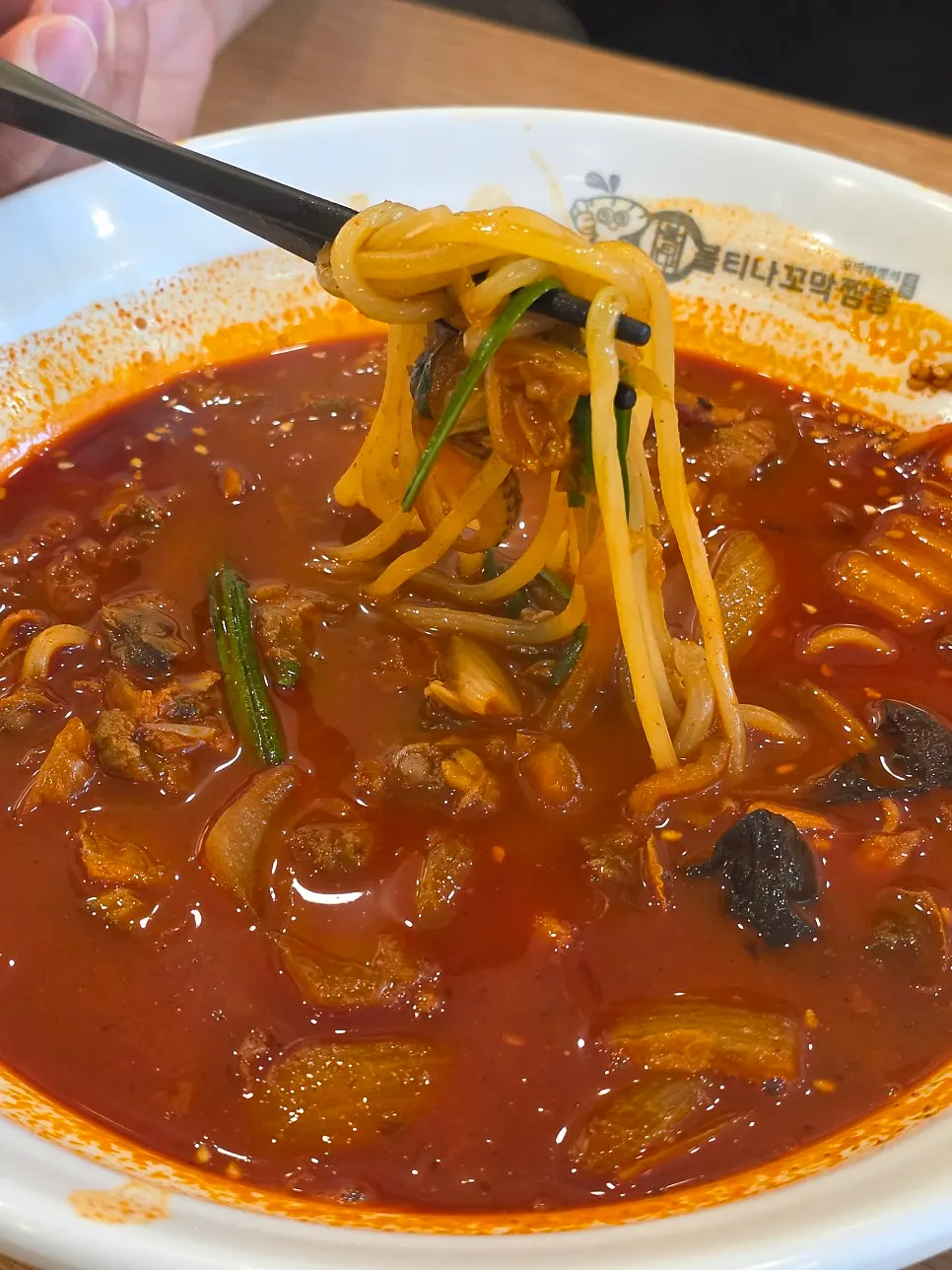 Jjamppong broth showing cockles and wood ear mushroom