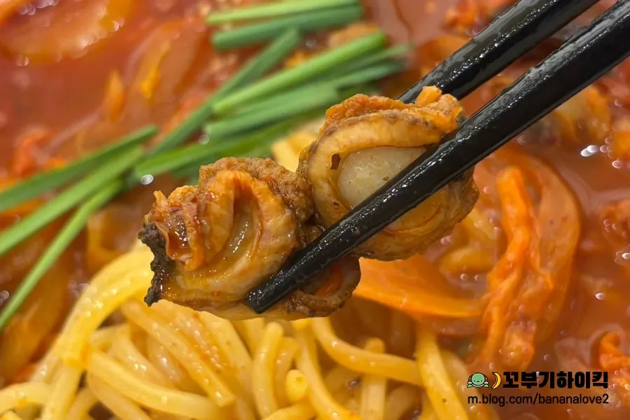 Jjamppong broth topped with cockles and shellfish