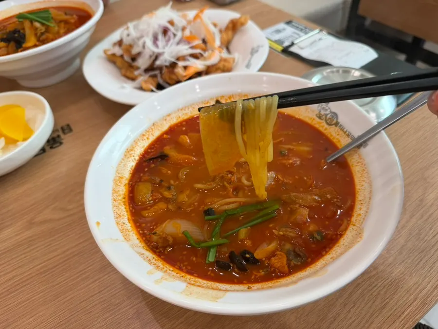 A spoon piled high with cockles and scallops
