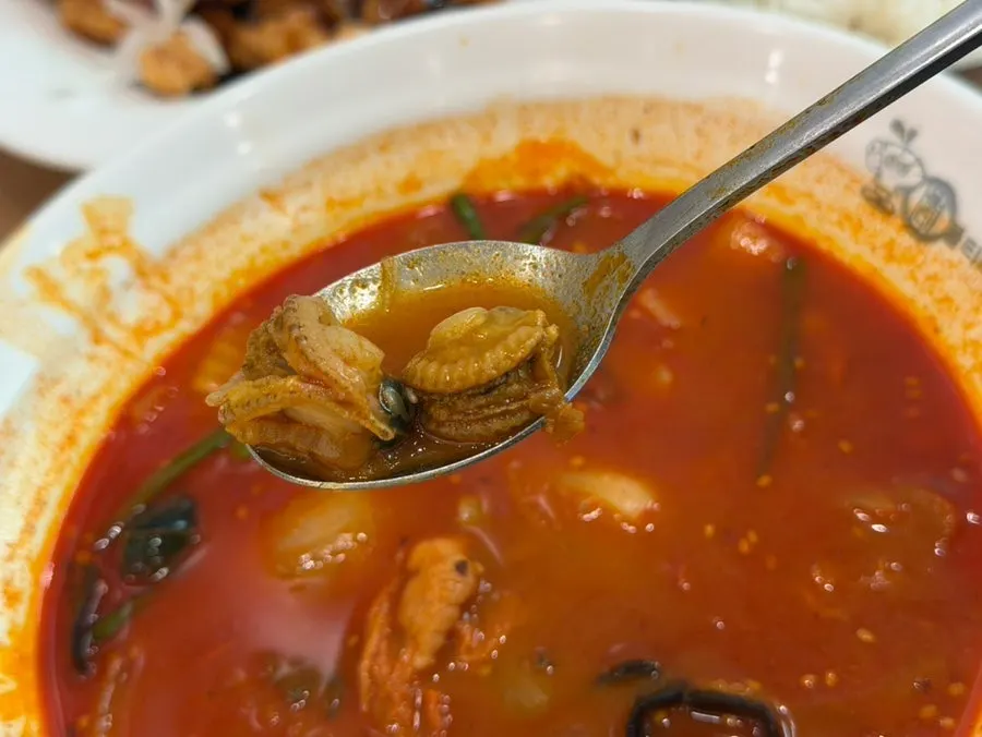 Jjamppong noodles soaked in broth and topped with cockles
