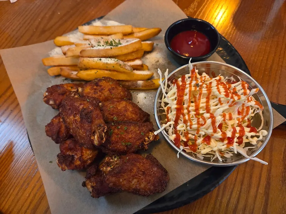 A plate of spicy red wings, drumettes and fries