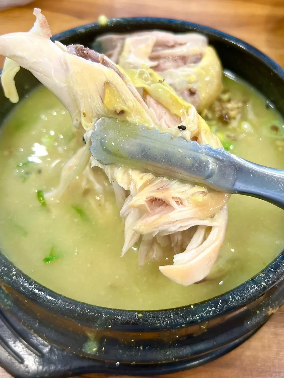 A piece of chicken dipped in the broth
