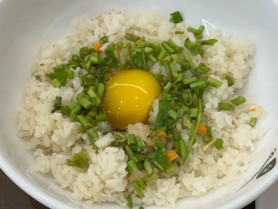 Fried rice ingredients topped with egg yolk