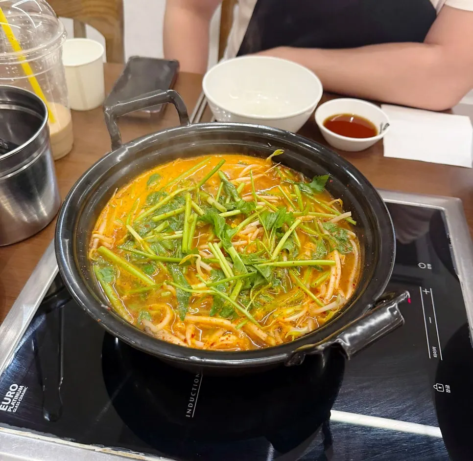 Shabu hot pot topped with minari and mung bean sprouts