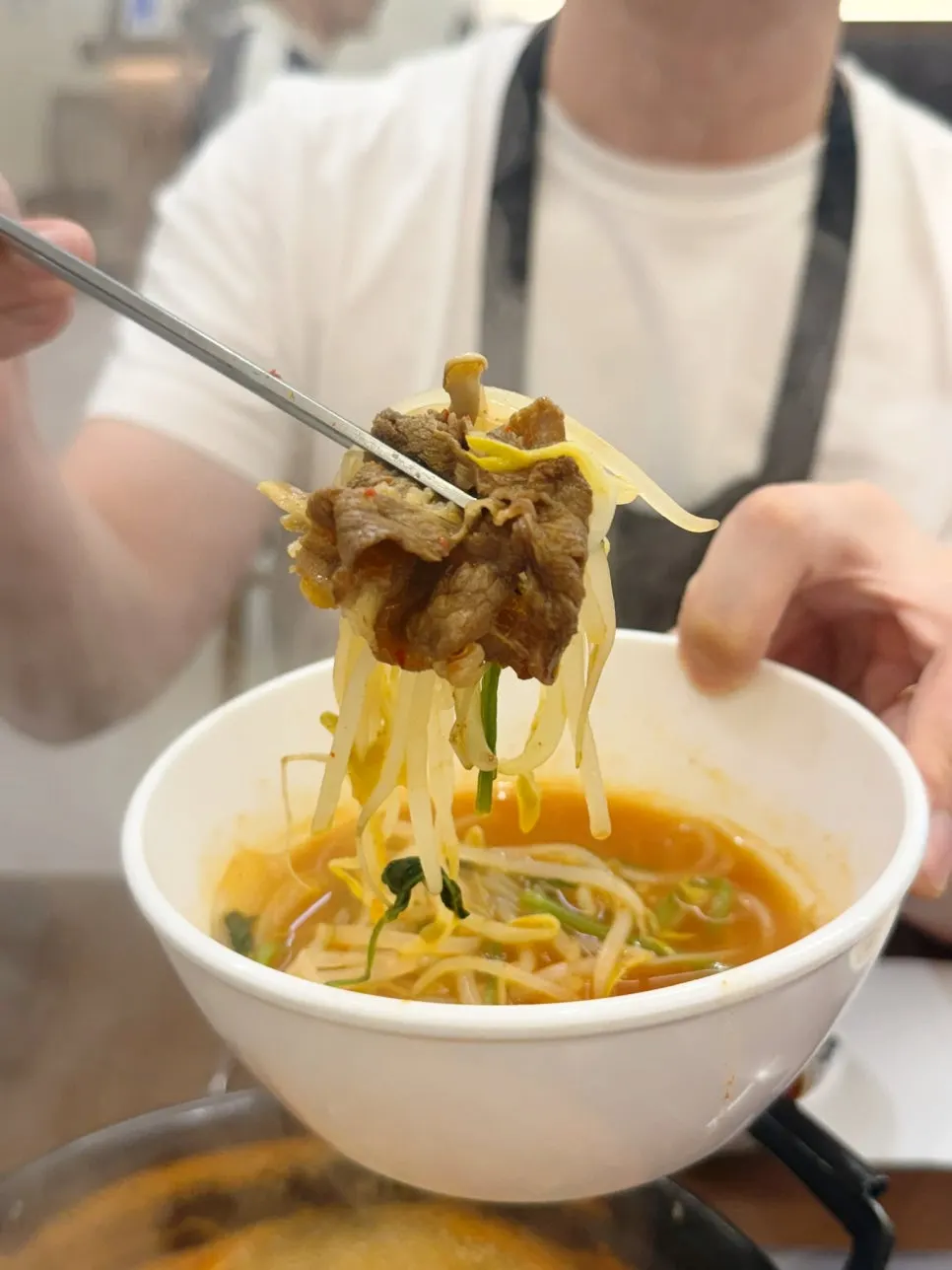 A bite of beef with minari and mung bean sprouts together