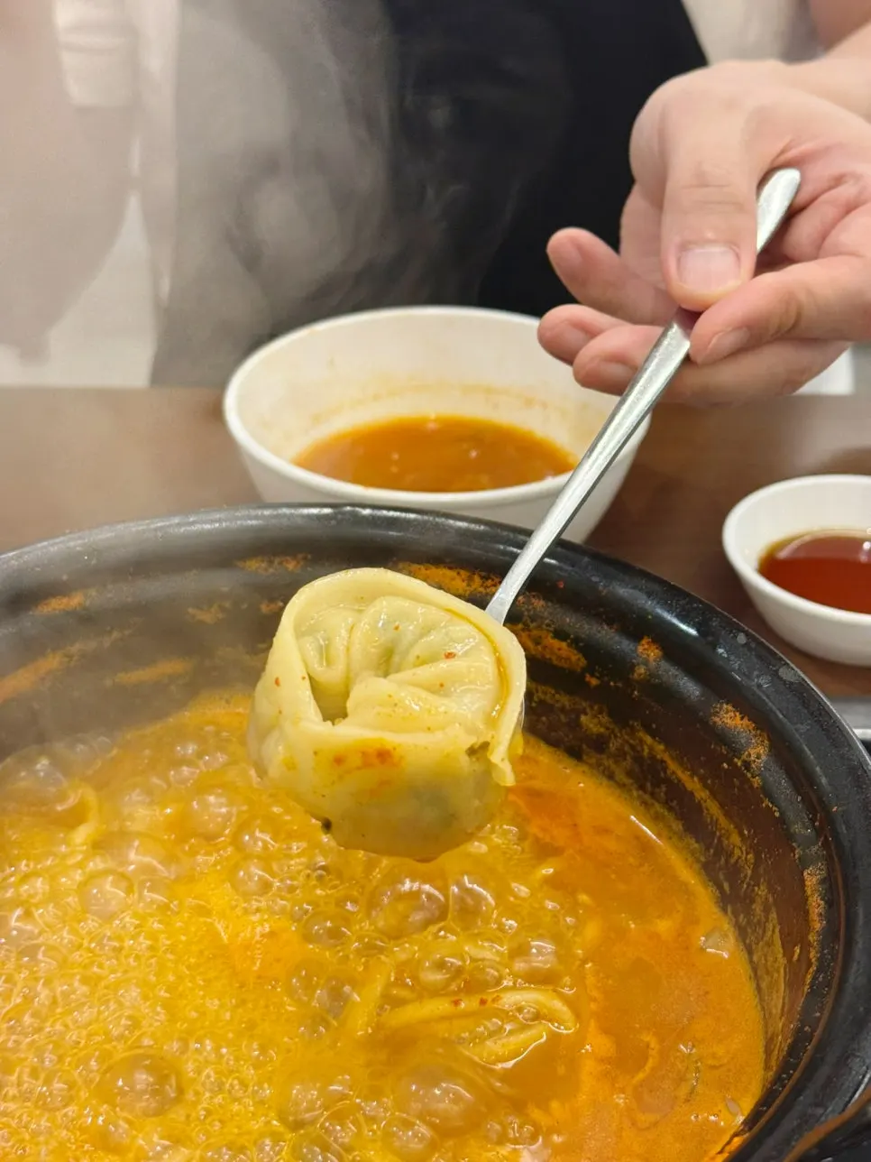 Kalguksu noodles simmering in the spicy broth