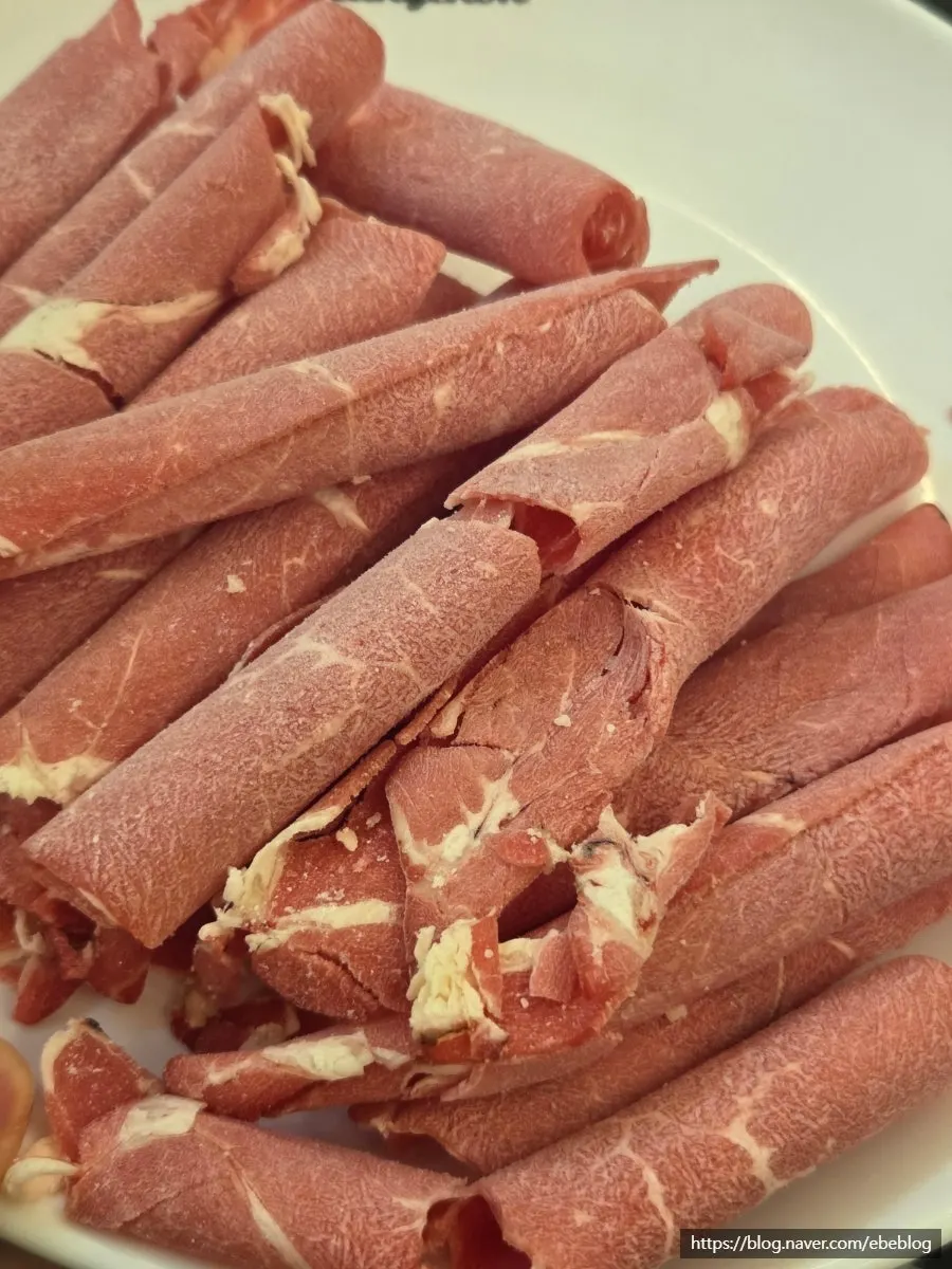 Thinly sliced shabu beef being cooked in the broth