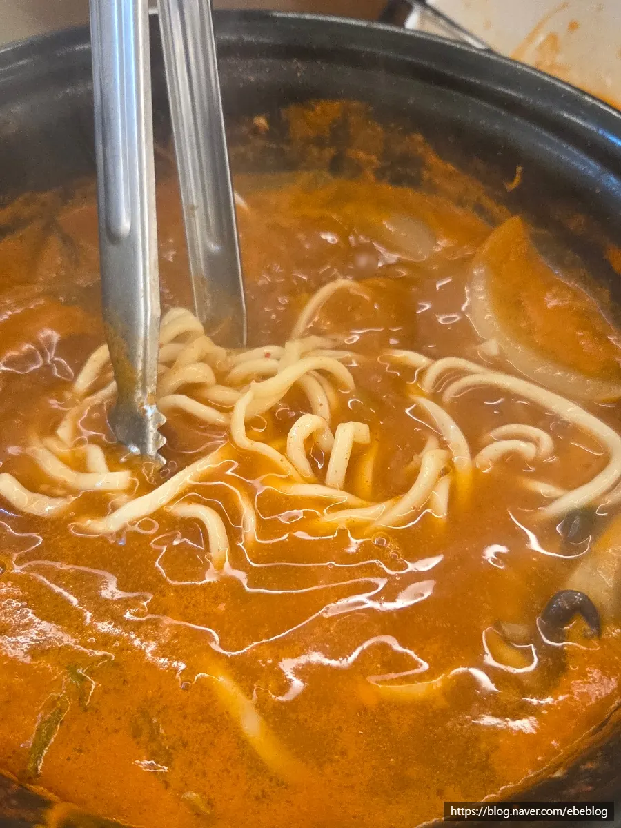 Kalguksu noodles added to the spicy broth