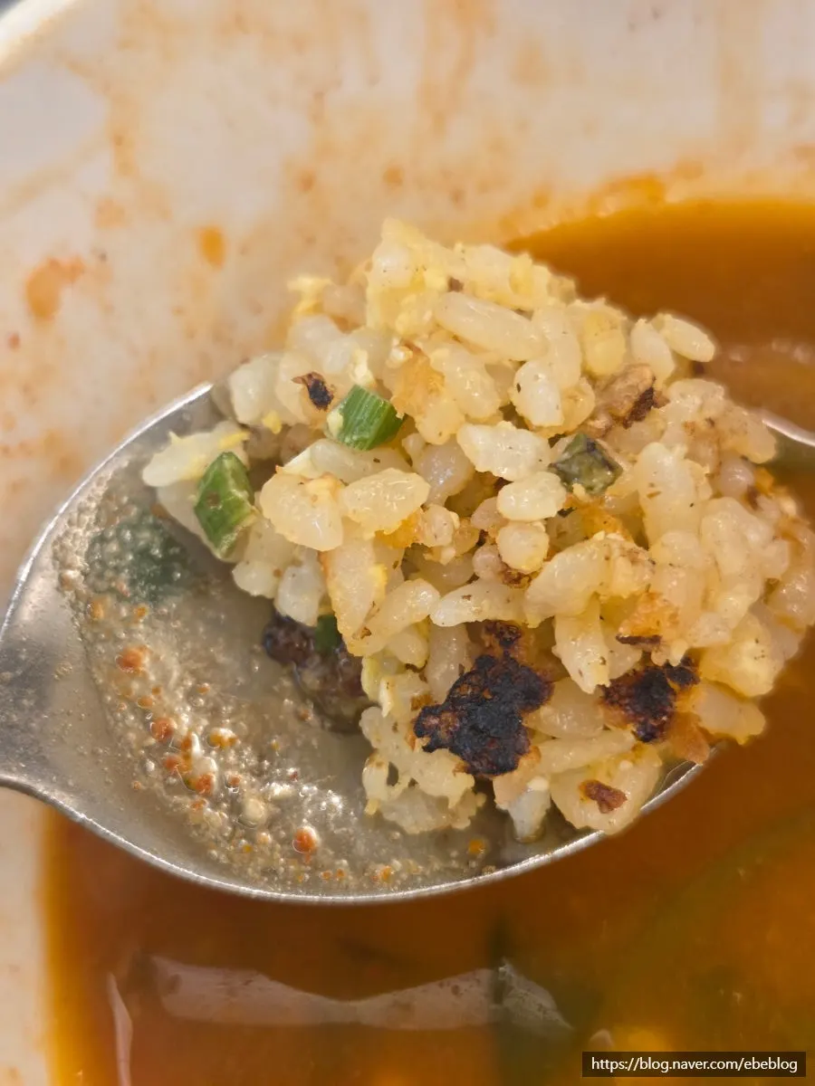 A spoonful of fried rice topped with kimchi