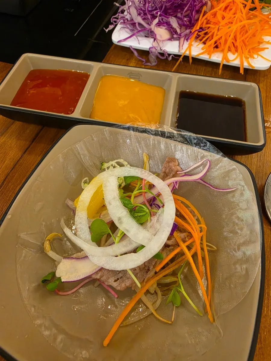 A bite of hinoki steam spring roll dipped in sauce