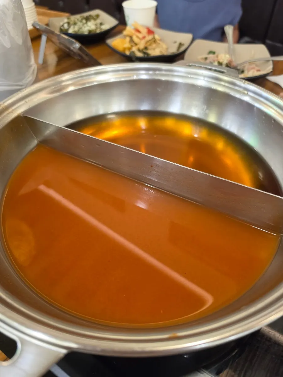 Meat and vegetables added to the boiling spicy broth