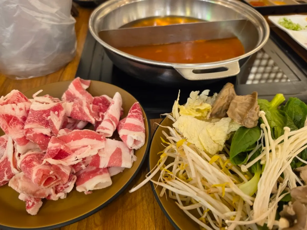 Table set with shabu-shabu meat and vegetable plates