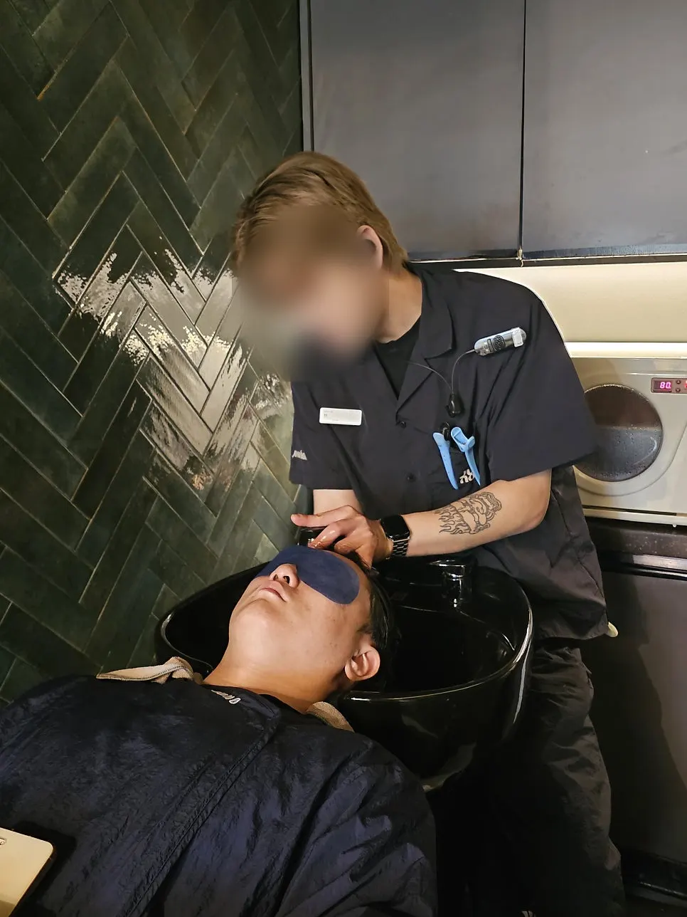 Lying down for a shampoo with an eye mask on