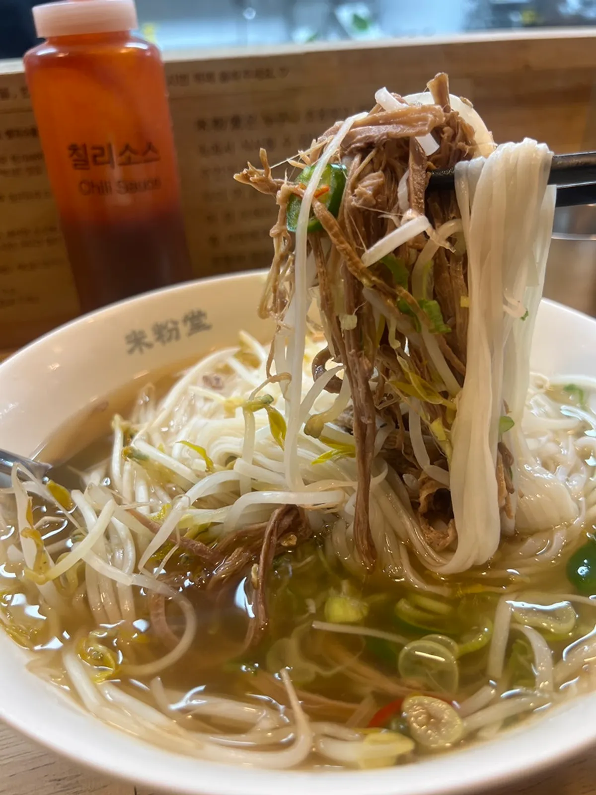 A bite of pho with brisket and bean sprouts together