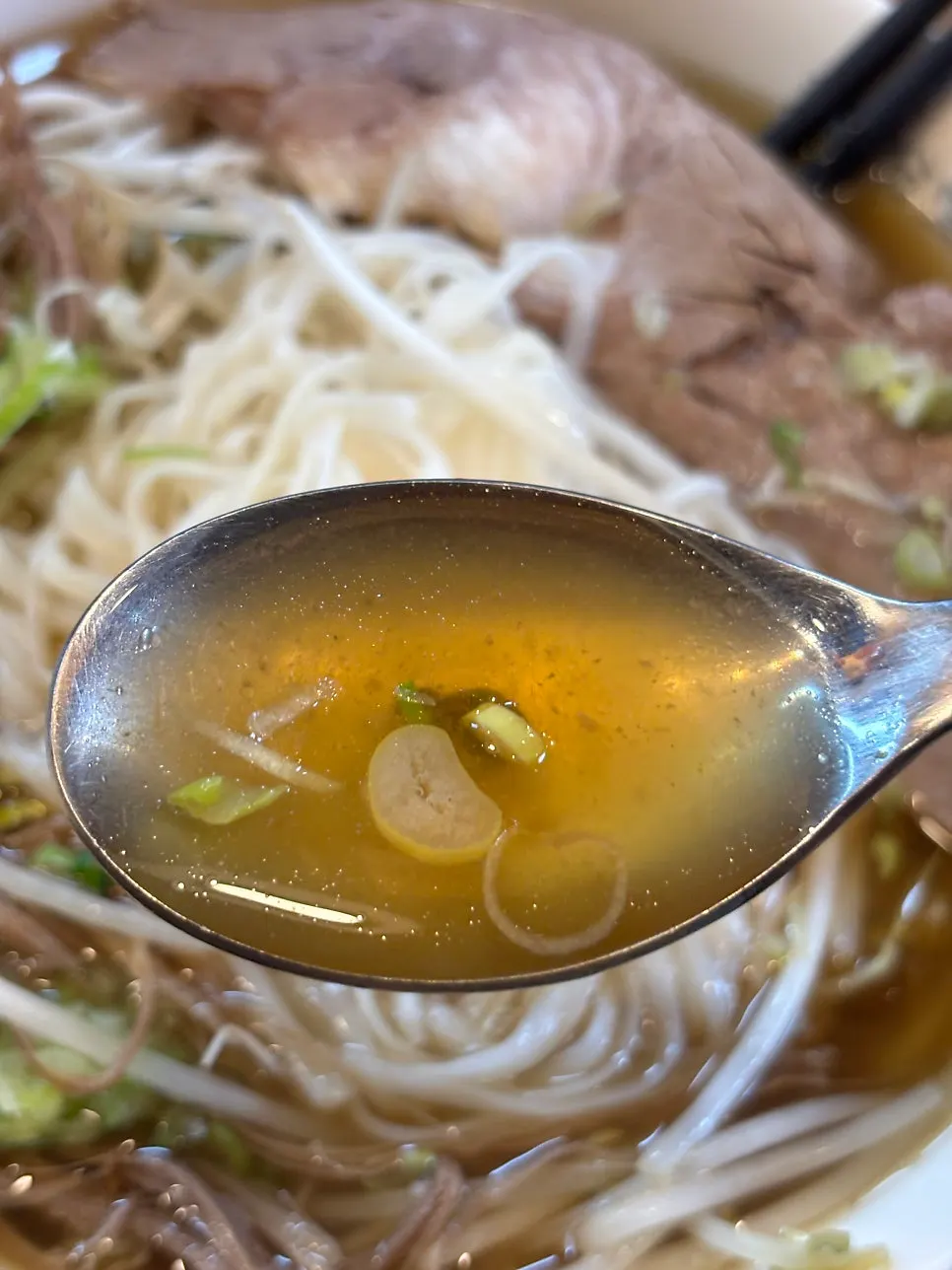 A bite of pho topped with bean sprouts