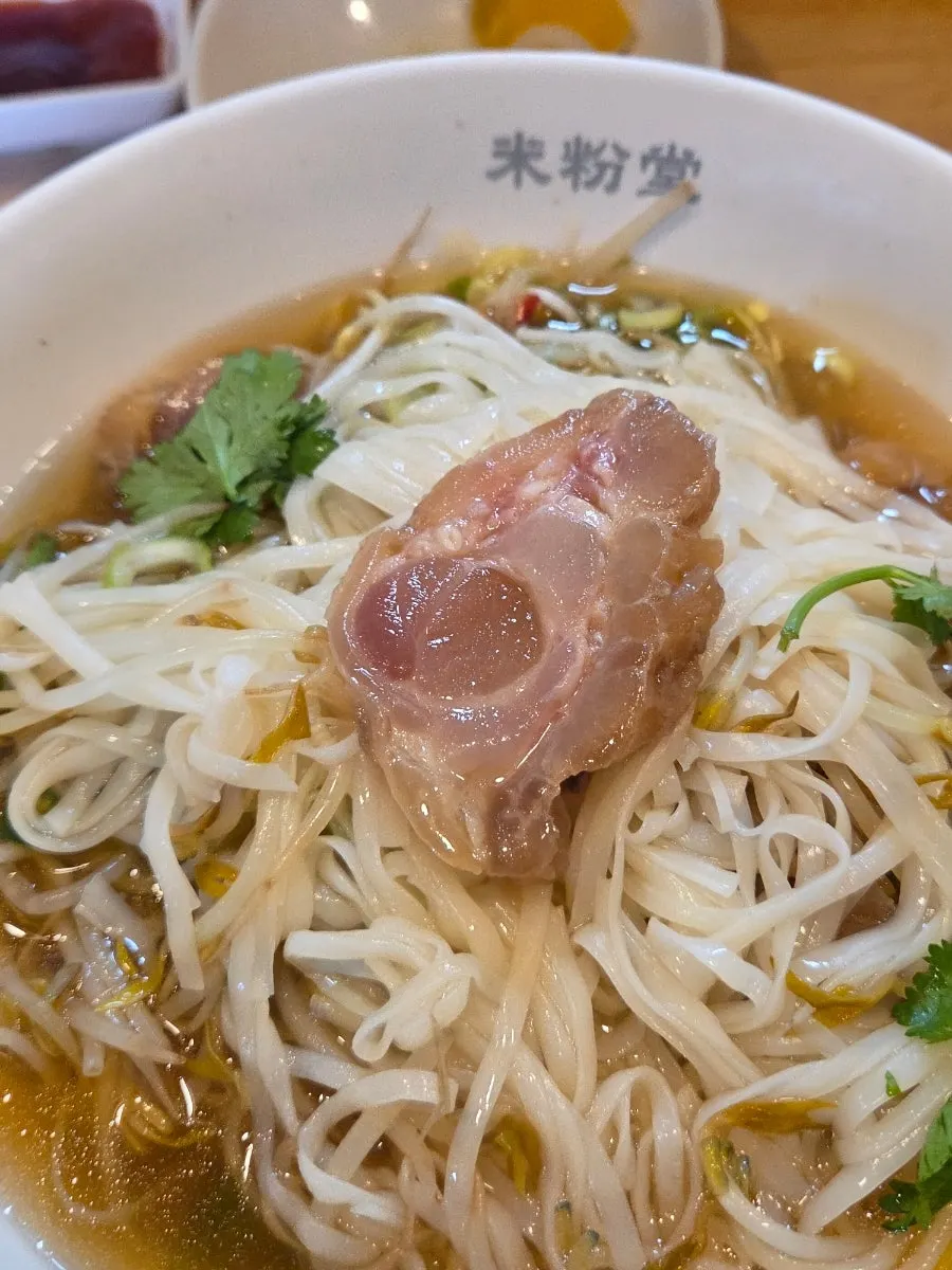 Pho noodles lifted with chopsticks