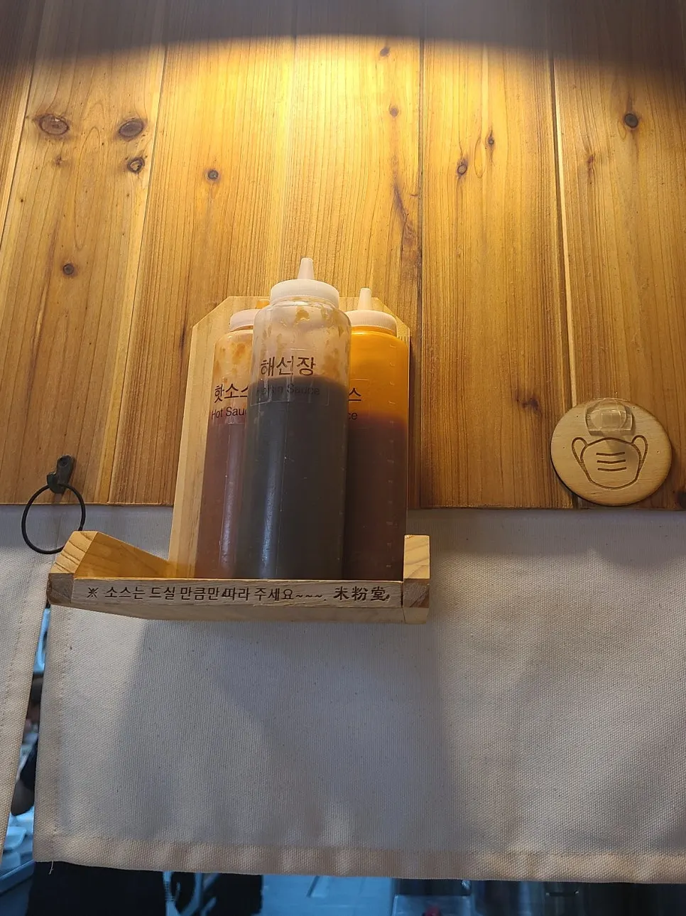 Hot sauce, hoisin sauce, and chili sauce placed above the table