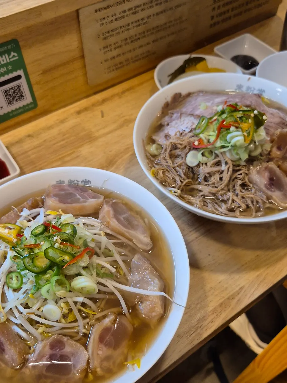 Table setting with the two ordered bowls of pho