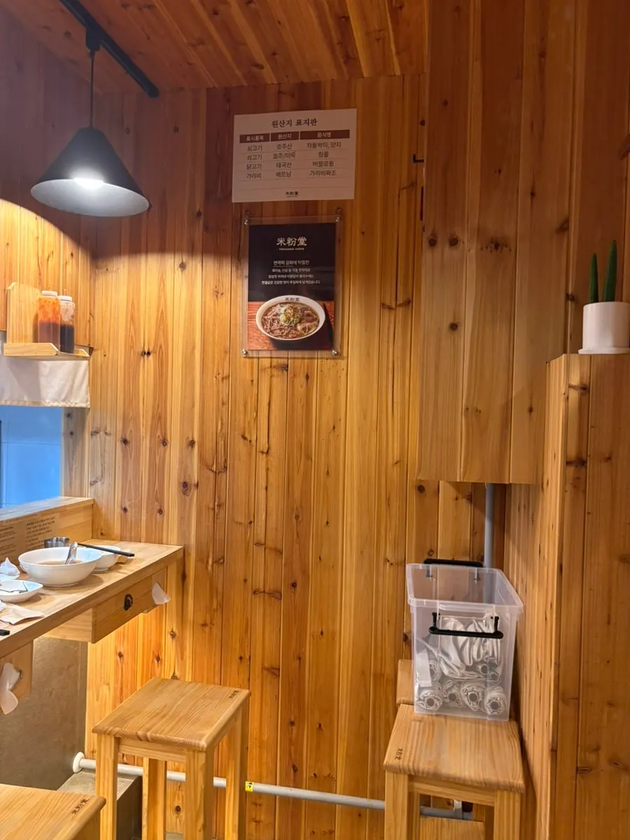 Wood-tone interior seating facing the open kitchen
