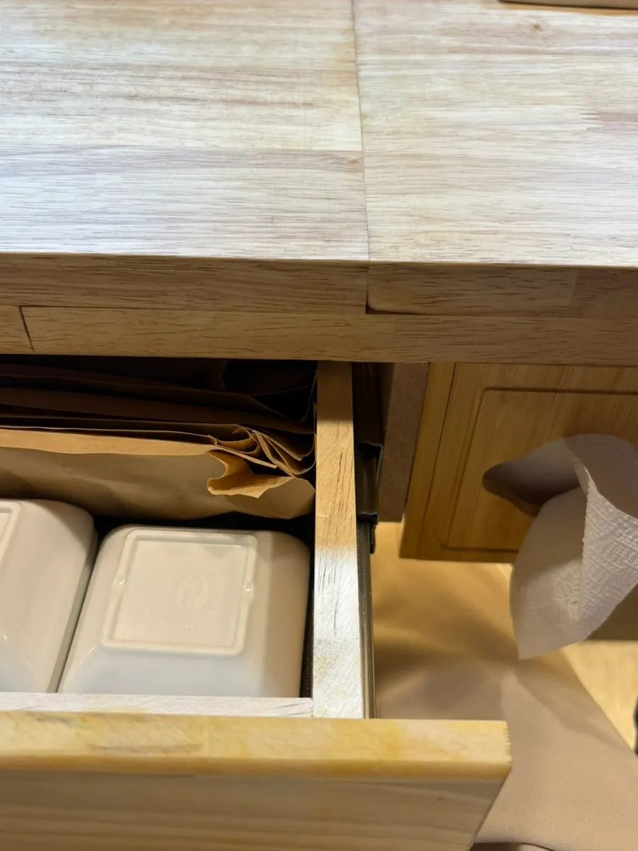 Small plates and utensils set up in a drawer under the table