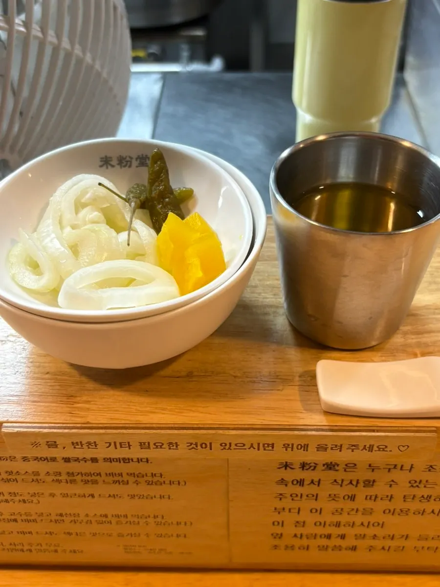 Onion, pickled radish, and pickled chili peppers set up on the bar table