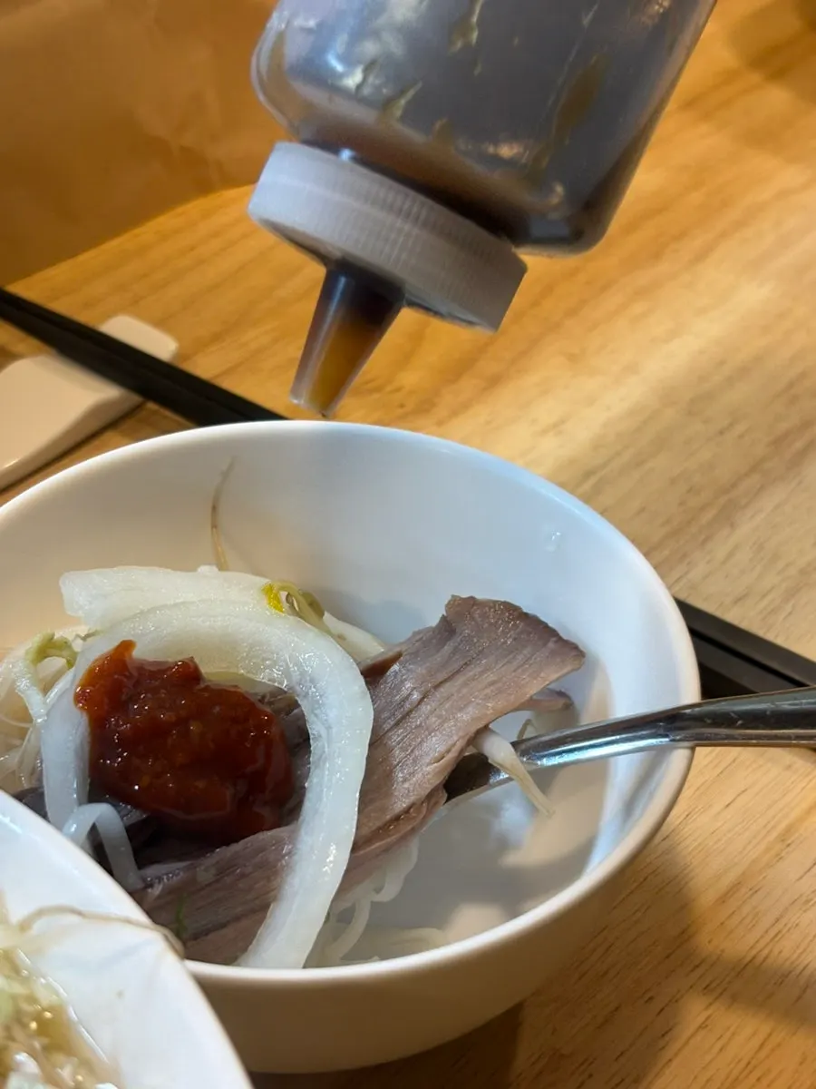 Pho mixed with sauce in a small plate