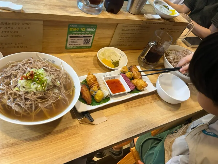 Table setting with pho and assorted fried appetizers