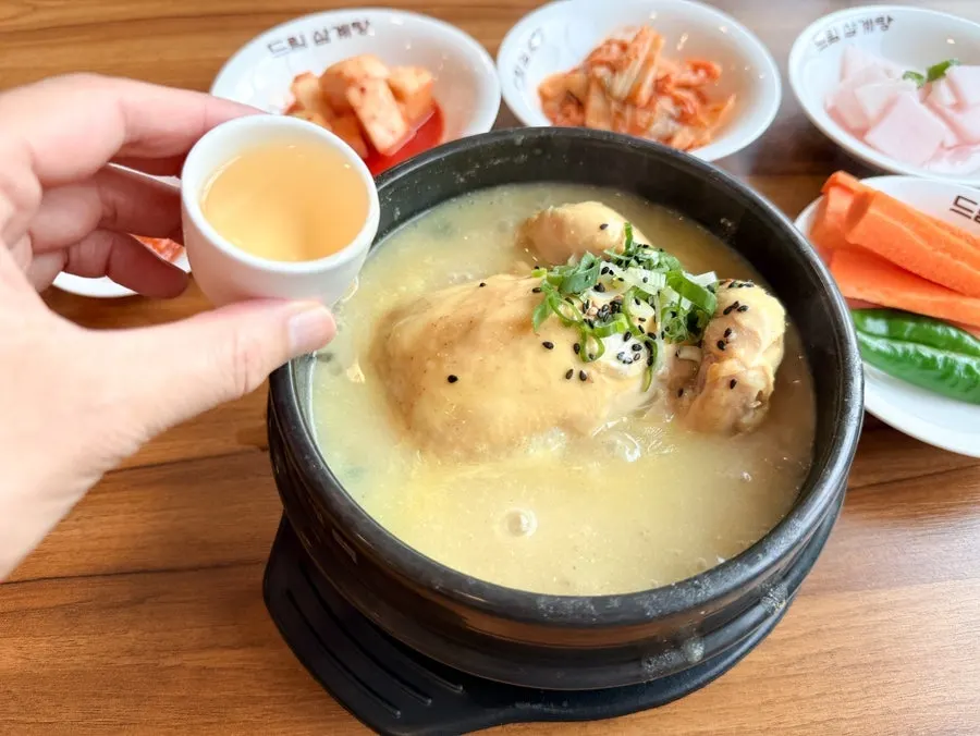 숟가락으로 떠올린 진한 삼계탕 국물