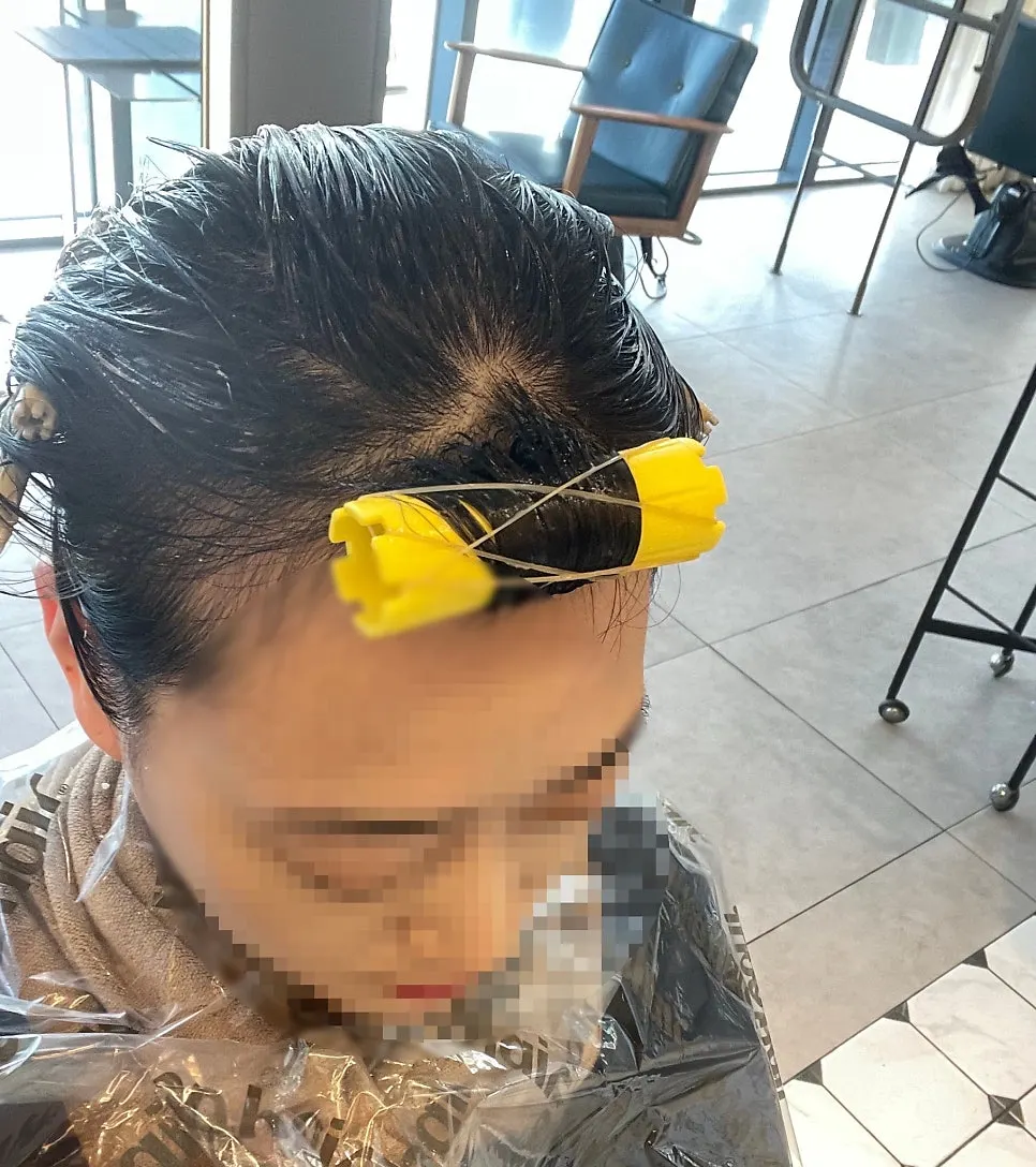 Smoothing hair with a flat iron during the volume magic process