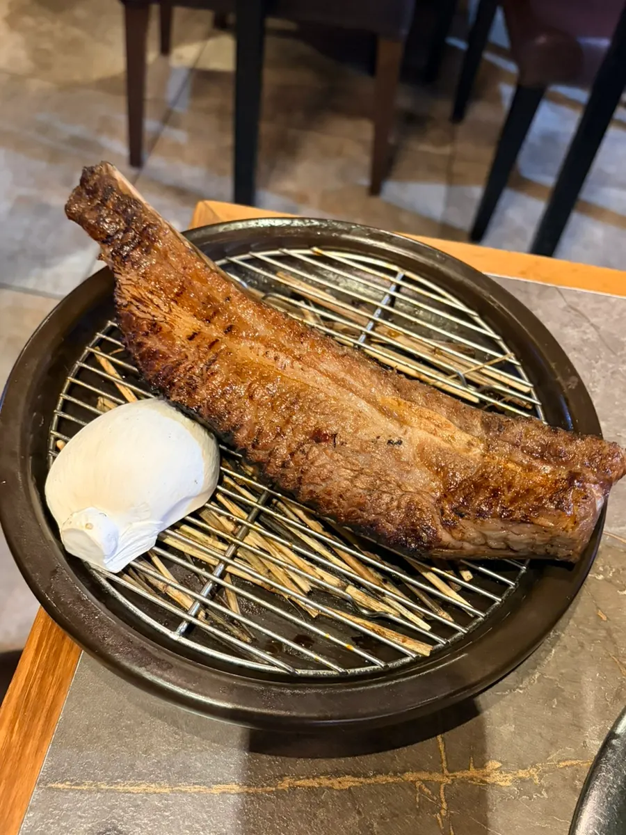 Prime beef ribs grilled over straw fire to order