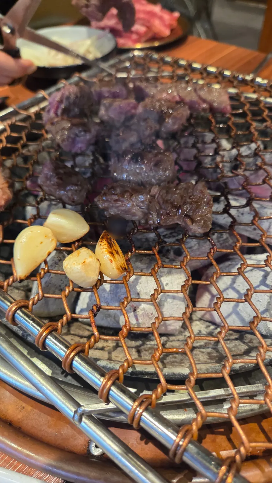 Meat grilling over charcoal at a Dongtan North Plaza BBQ restaurant