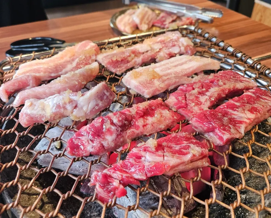 Beef and pork placed half and half on the charcoal grill