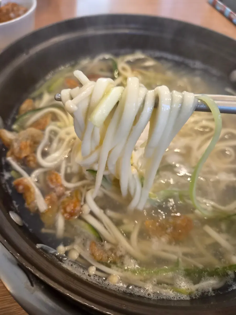 Seafood kalguksu simmering at the table