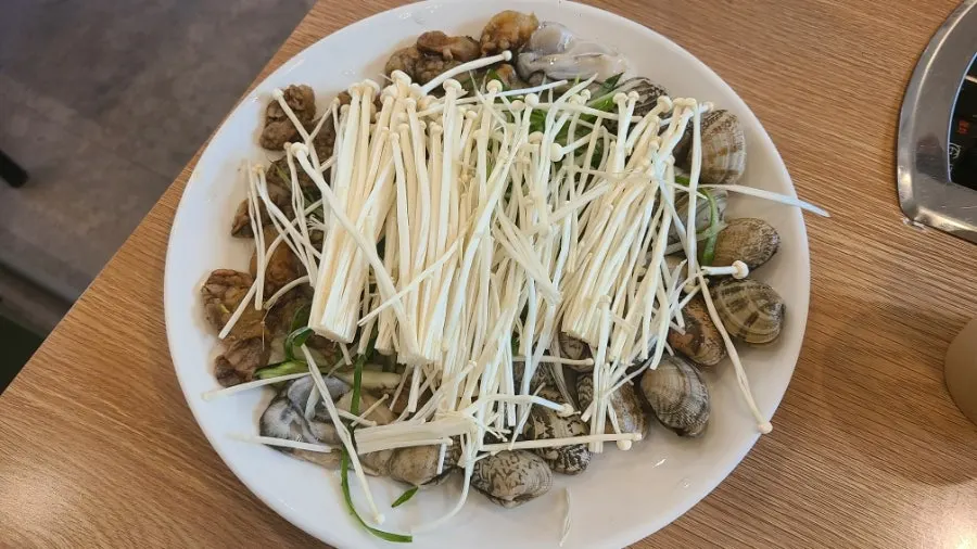 Pot of Yubok haemul kalguksu piled with seafood