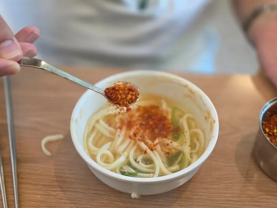 Red pepper flakes sprinkled over the kalguksu