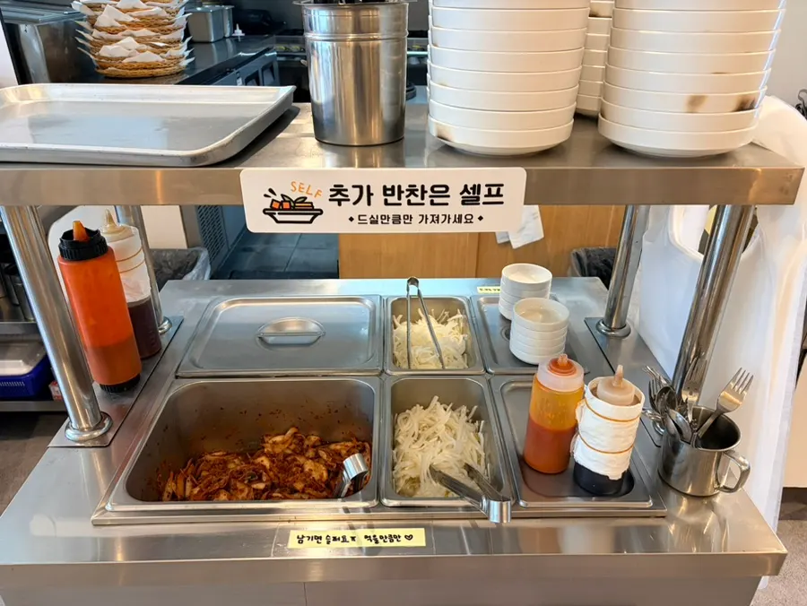 Self-serve side-dish corner with fresh kimchi and shredded radish
