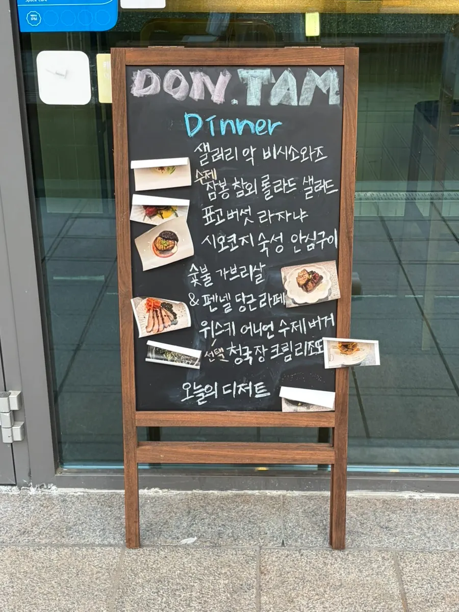 코스 순서와 시즌 요리 사진이 붙은 매장 외부 입간판