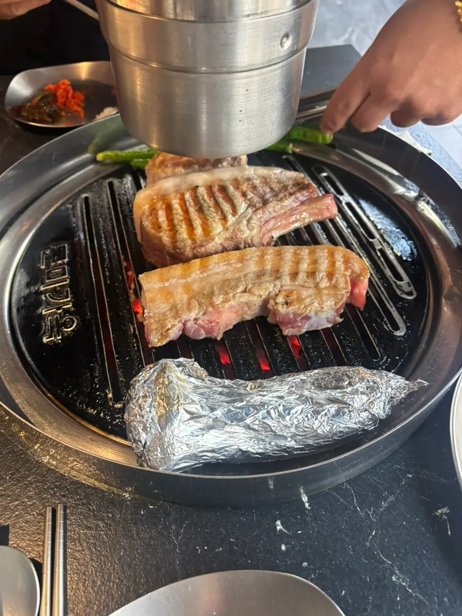 직원이 불판에서 고기를 구워주는 모습