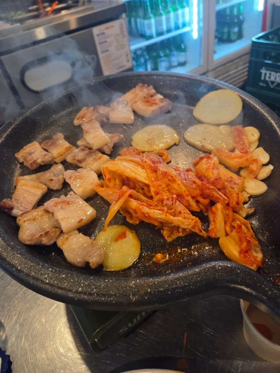 Fresh pork belly with potato, mushroom, and kimchi on the grill