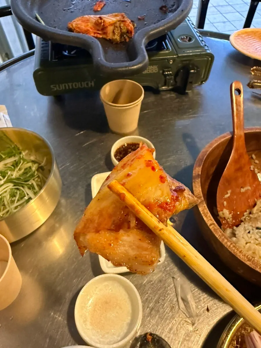 구운 김치를 올린 삼겹살 한 점