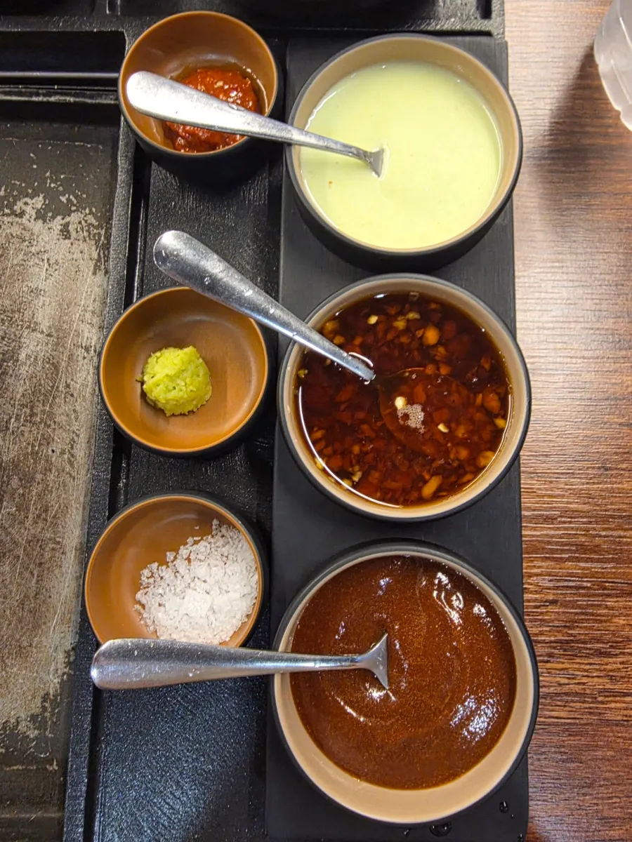Six sauces served alongside the meat